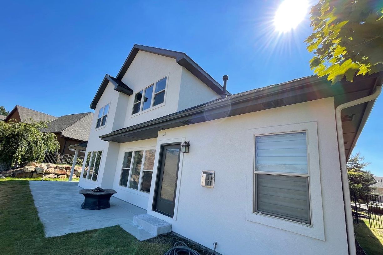Side view of house with patio and sunny sky