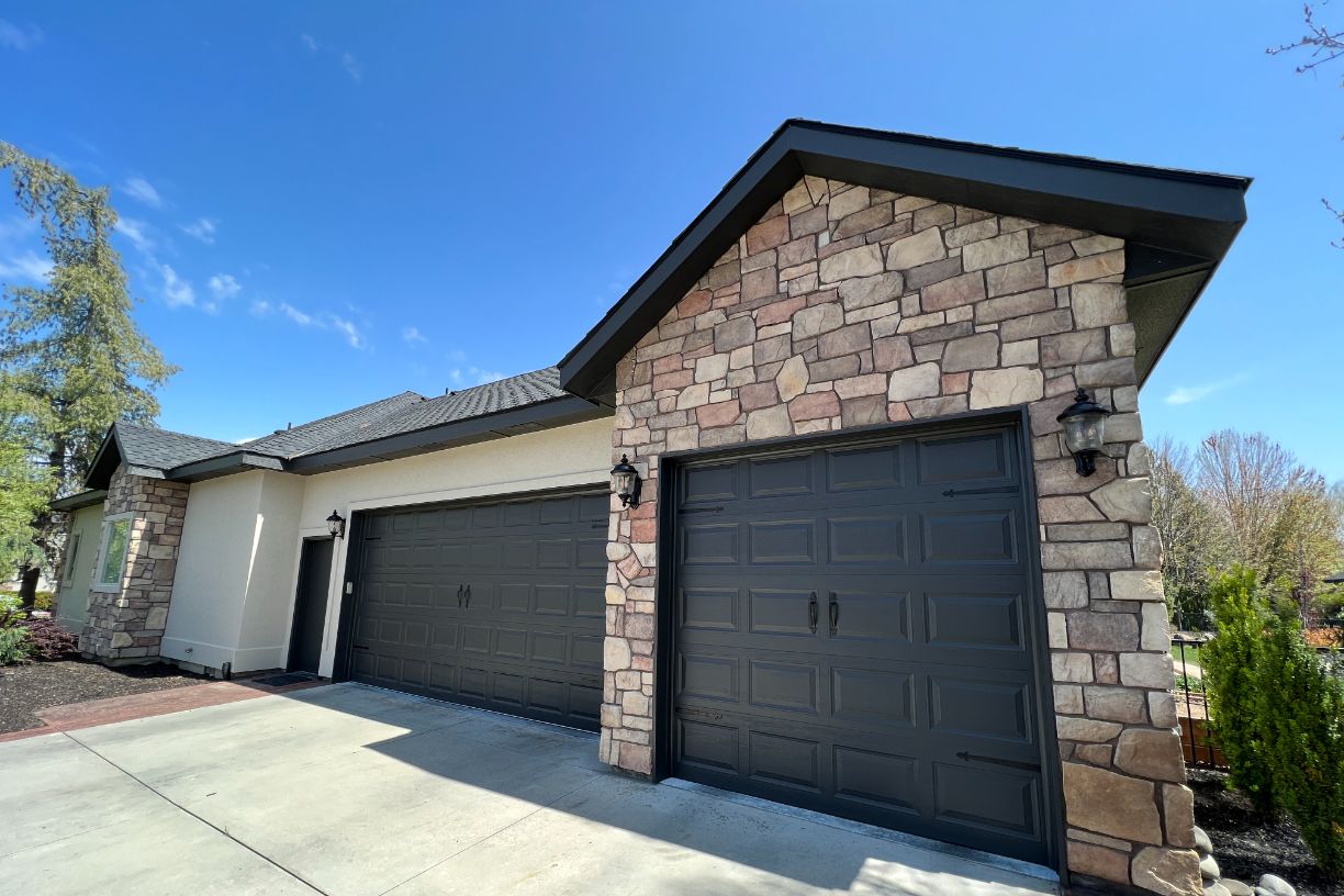 Professional exterior painting on stone-accent home