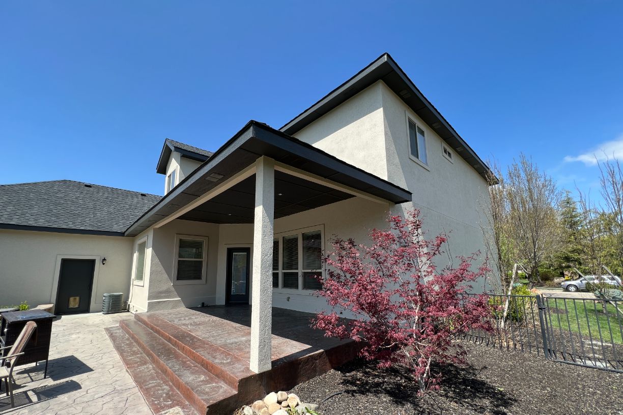 Backyard view of house with porch and landscaped garden