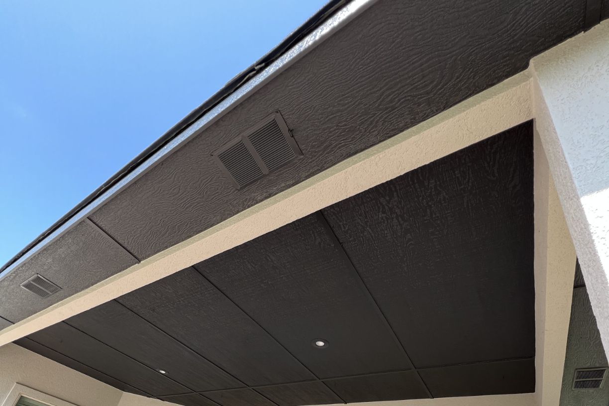 Close-up of house eaves with dark ceiling and vents