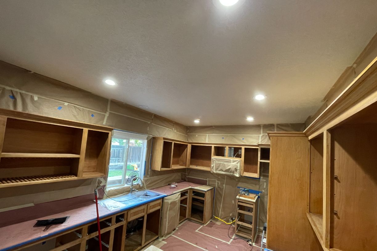 Kitchen under renovation with protective covering and unfinished cabinets