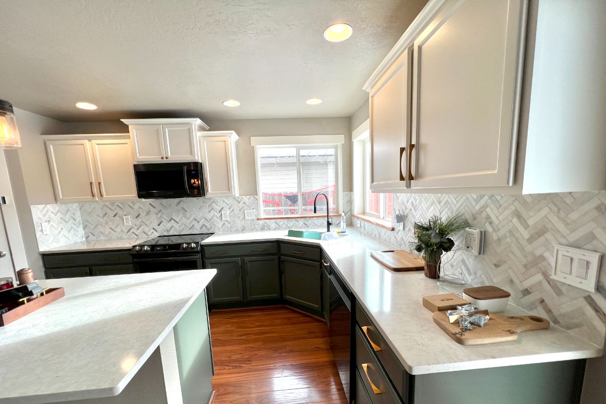 Modern kitchen with green cabinets, white countertops, and microwave