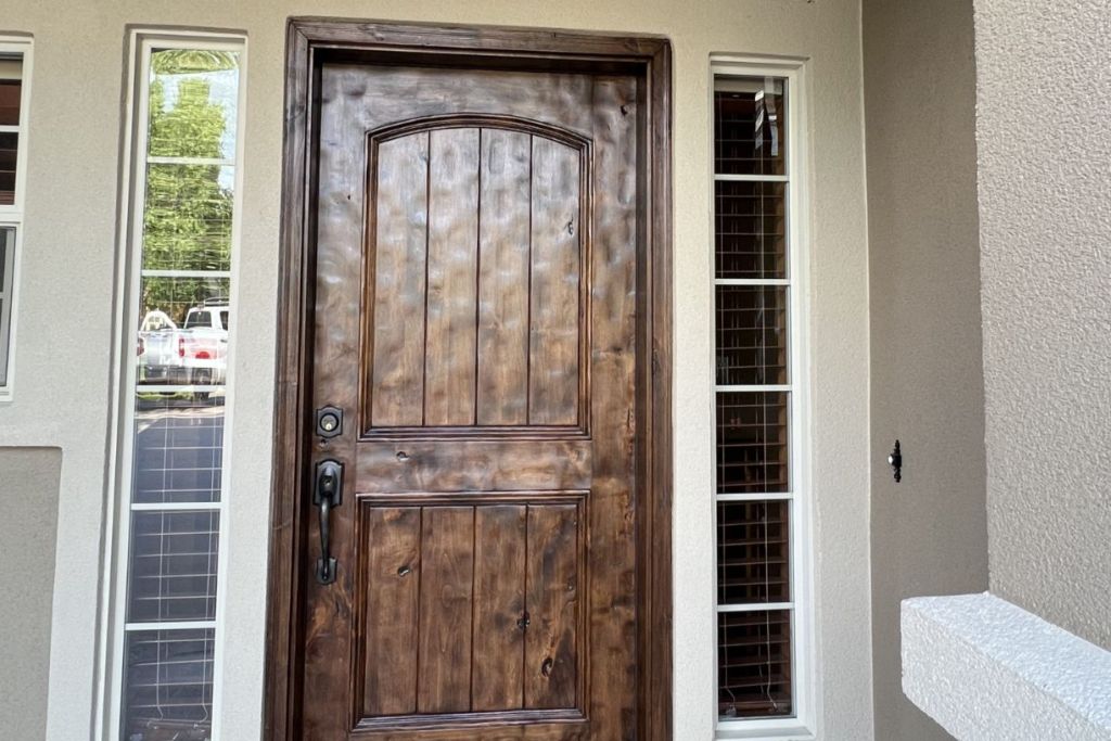 Rustic wooden front door with sidelights