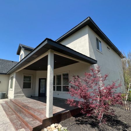 Backyard view of house with porch and landscaped garden
