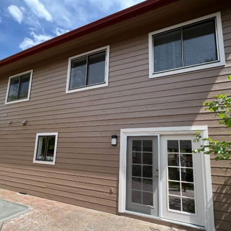 Backside view of house with large windows and door