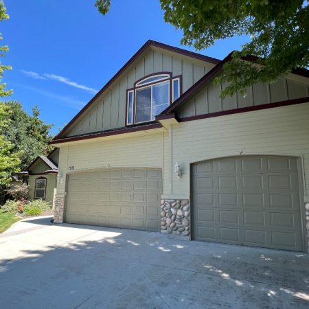 Two-car garage with stone accents and greenery