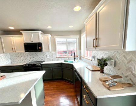 Modern kitchen with green cabinets, white countertops, and microwave