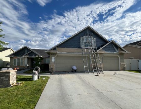 House exterior being painted with ladders
